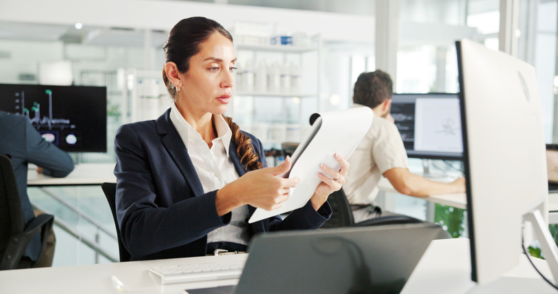 Laptop, reading or businesswoman with documents for research, financial news or profit evaluation. Budget, finance advisor or economist with paper for company revenue growth, payroll or investment